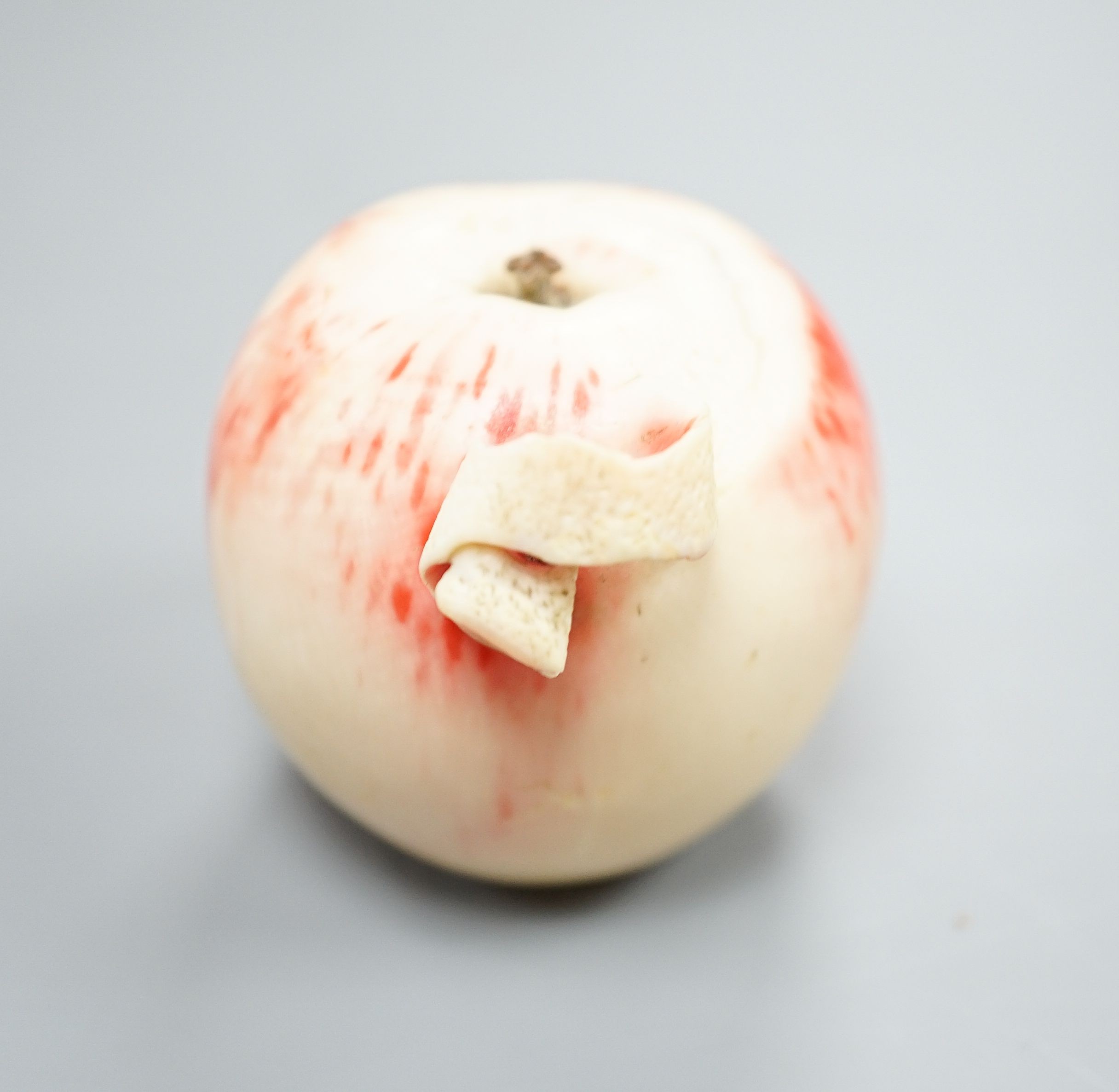 A Japanese carved ivory model of a partially peeled apple, c.1900, 5cm